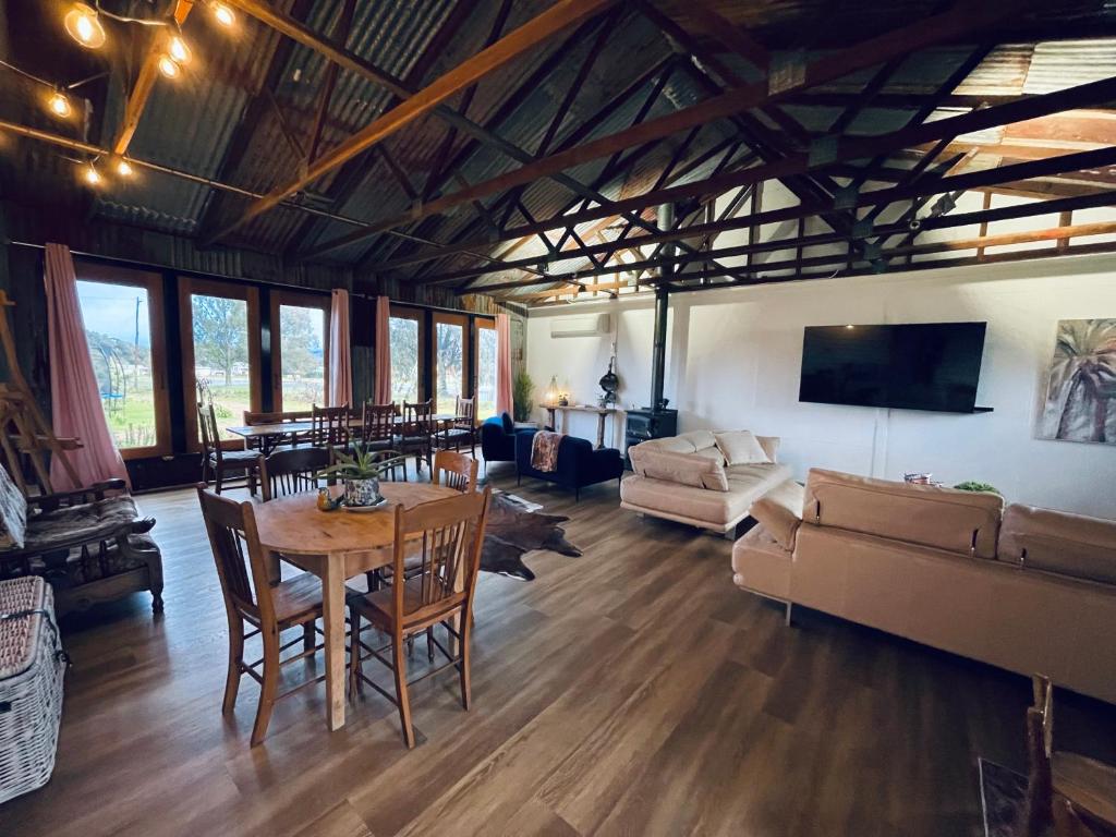 - un salon avec une table et un canapé dans l'établissement Barn Cottage Granite Belt Tiny Town Stay, à Wallangarra