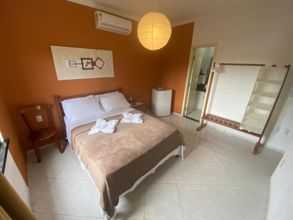 a bedroom with a bed with two flowers on it at Refúgio Pousada Fortaleza in Fortaleza