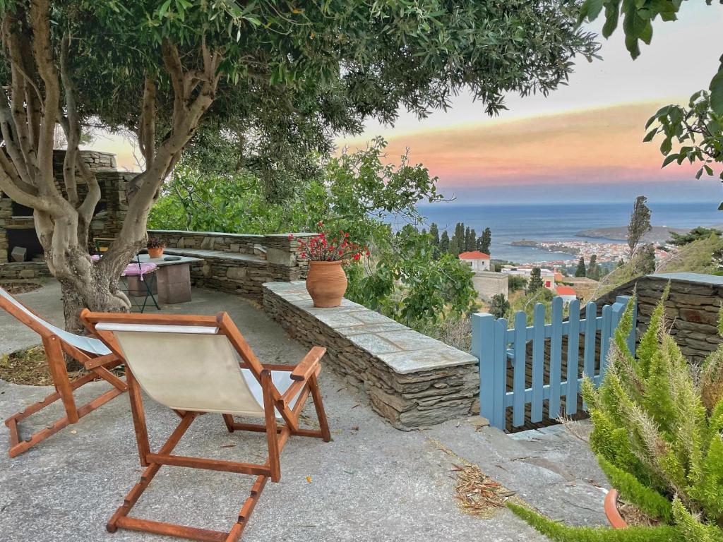 een stoel op een patio met een blauw hek bij The Walnut Tree - Cycladic Getaway with Sea Views in Lámira