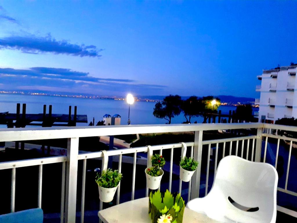 a balcony with a white chair and potted plants at SUN SEA No 3 in Perea