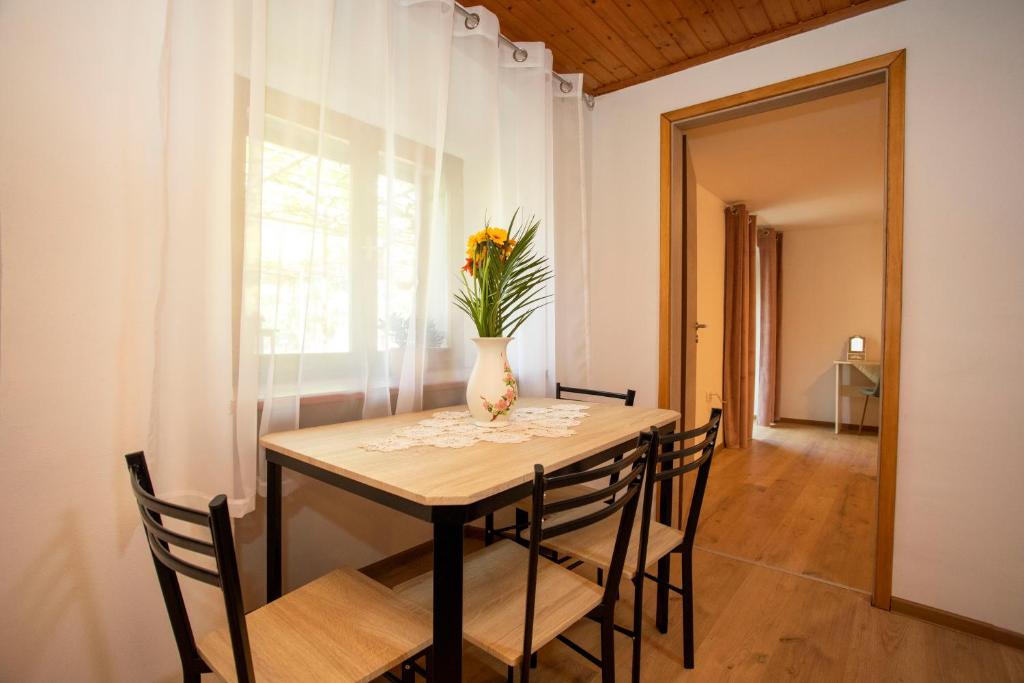 stół jadalny z wazonem kwiatów w obiekcie Holiday house Nono w mieście Labin