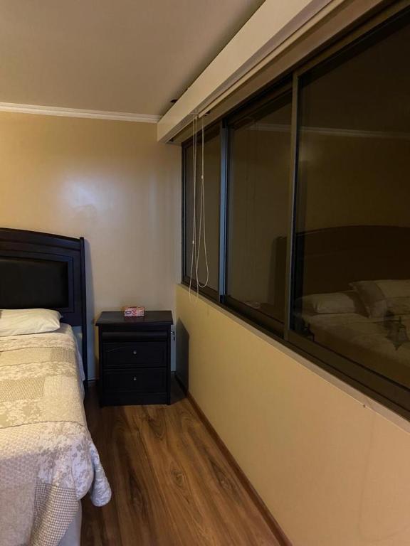 a bedroom with a bed and a large window at CASA VILLA AZUL 3 PISOS in Antofagasta