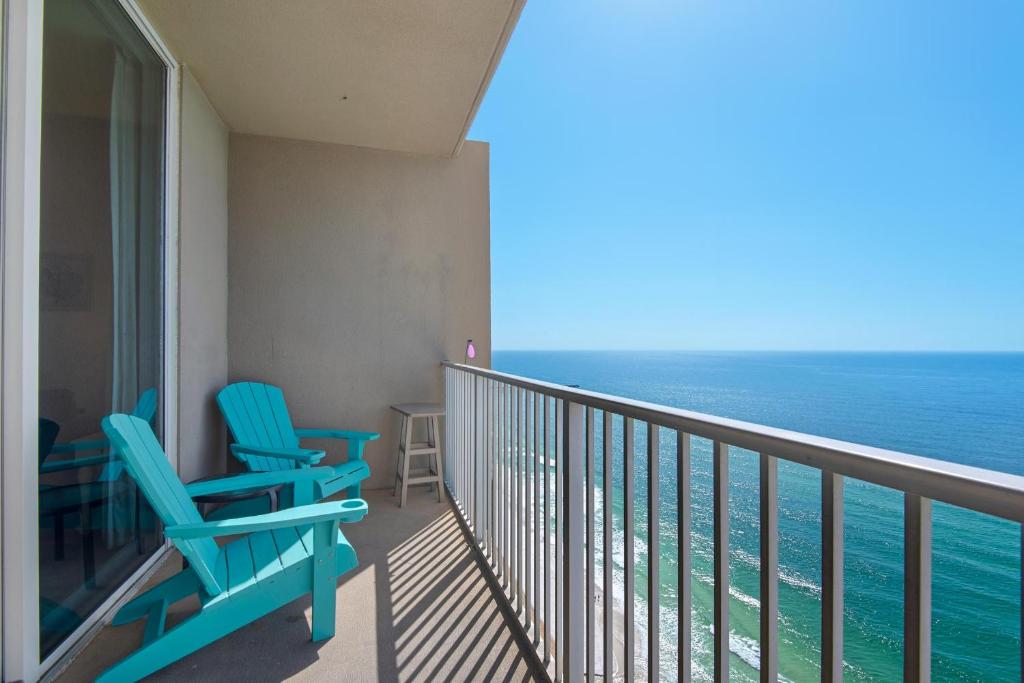 un balcón con 2 sillas azules y el océano en Tidewater 3013 en Panama City Beach