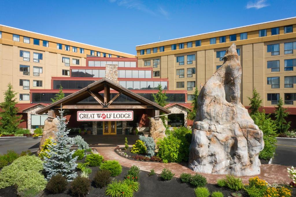 a hotel with a statue in front of a building at Great Wolf Lodge New England in Leominster