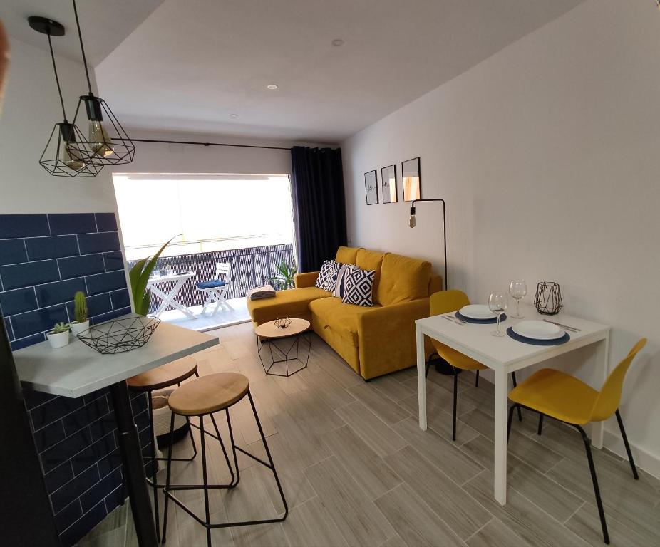 een woonkamer met een bank en een tafel en stoelen bij The2G Beach Apartment in Torremolinos
