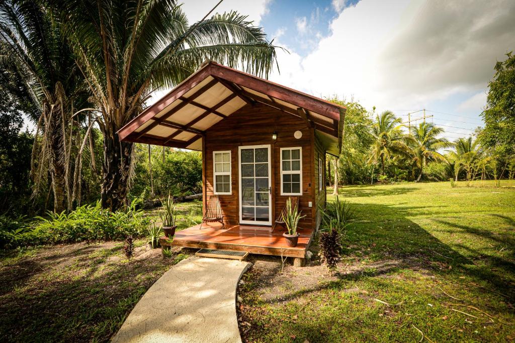 a small tiny house with a porch in a field at KikiWitz Resort in Belmopan