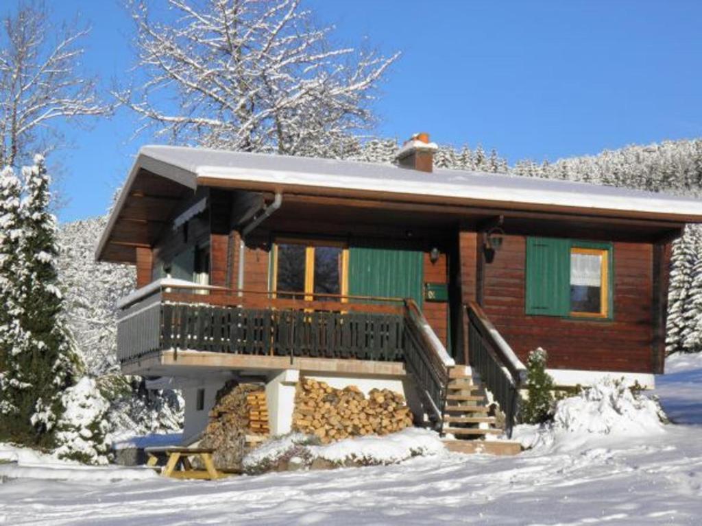 a log cabin in the snow with a balcony at Chalet rénové proche du Valtin – Idéal pour famille, randonnées et ski, Wifi, luges fournies - FR-1-589-150 in Ban-sur-Meurthe-Clefcy