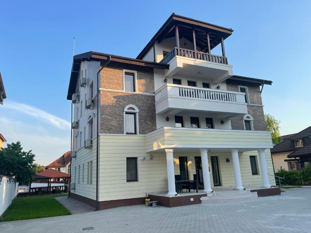 a tall building with a balcony on top of it at Iarca Inn in Bucharest