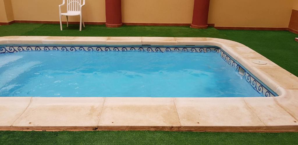 - une piscine avec une chaise dans la cour dans l'établissement Playa del Cura, à Torrevieja