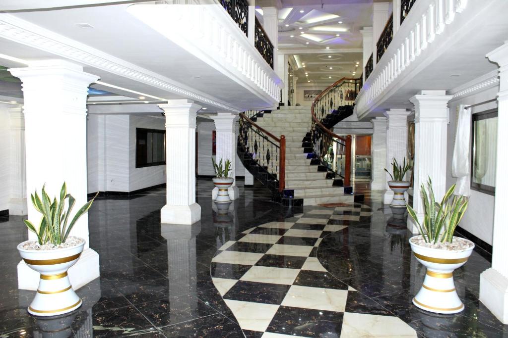 a lobby with a black and white checkered floor and stairs at RESIDENCE PALAIS DU STADE in Cotonou