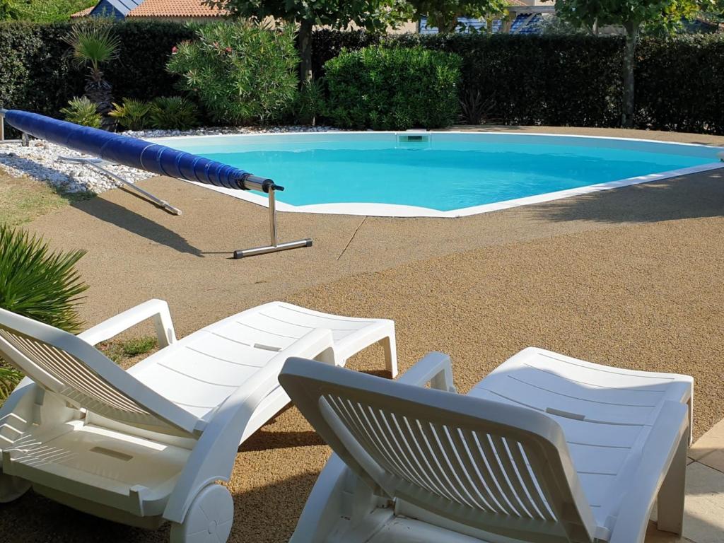 dwa leżaki i parasol przy basenie w obiekcie Villa Les Sables-d'Olonne, 4 pièces, 6 personnes - FR-1-485-115 w mieście Les Sables-dʼOlonne