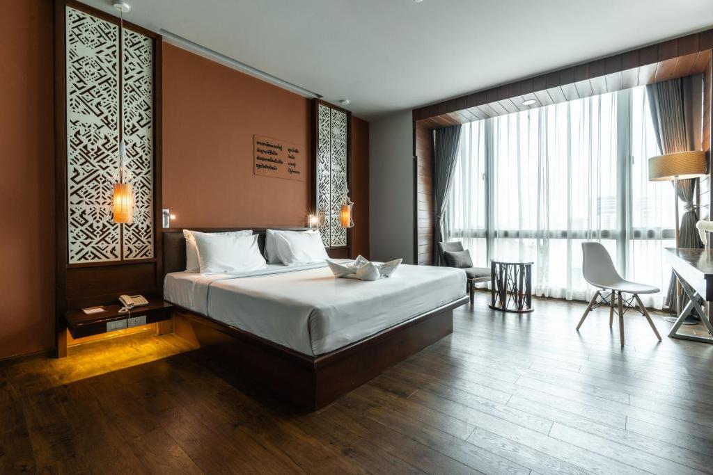 a bedroom with a bed and a desk in a room at Grand Hotel Vientiane in Vientiane