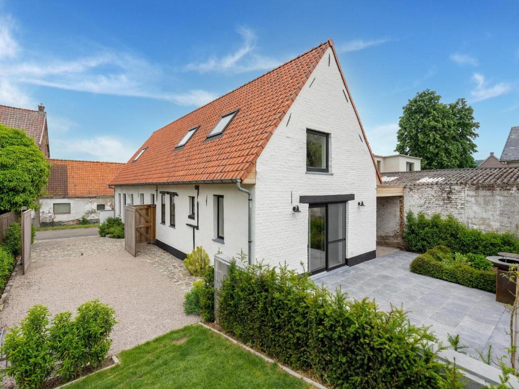 a white house with an orange roof and a courtyard at Spacious Family Holiday Home in Mont-de-l'Enclus