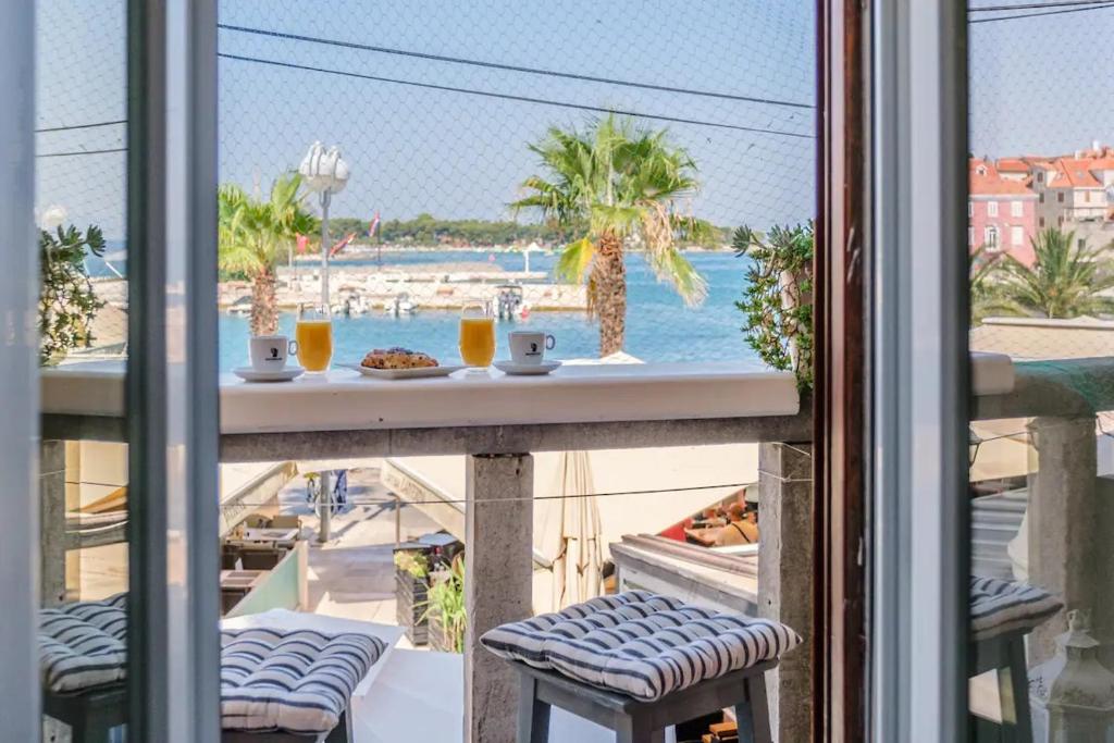 einen Balkon mit Poolblick und einem Tisch in der Unterkunft Apartment Vin - sea promenade in Supetar