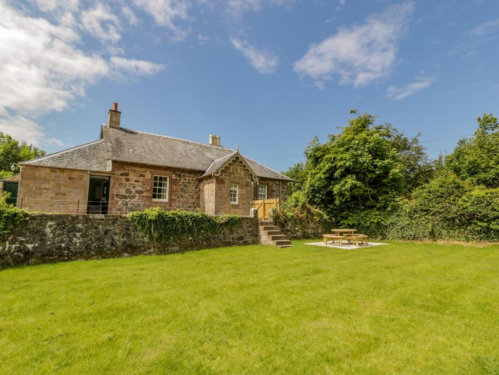 an old stone house with a grass yard at North Firbank - Culzean Castle in Maybole