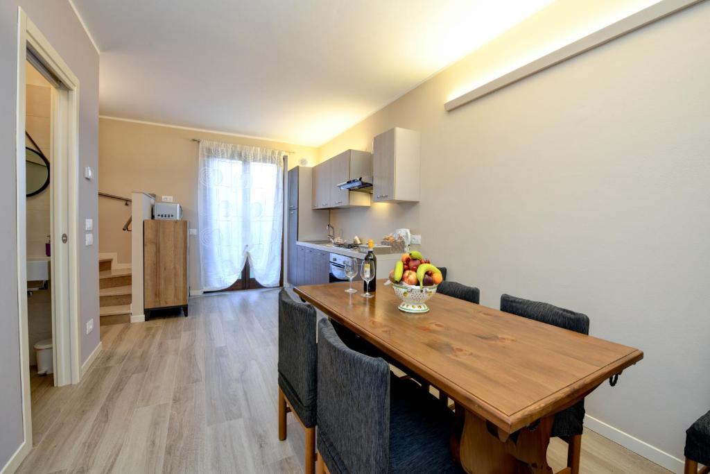 een keuken en eetkamer met een houten tafel en stoelen bij Casa Francesca in Sirmione