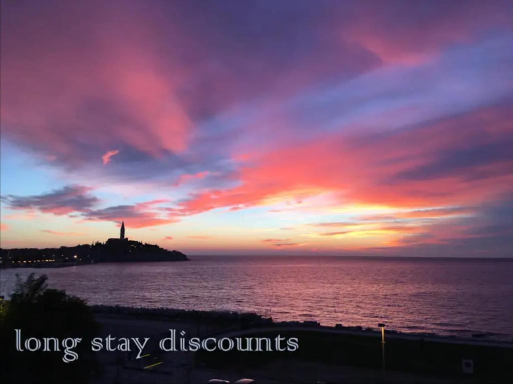 ロヴィニにあるApartment with a viewの島の灯台と海に沈む夕日