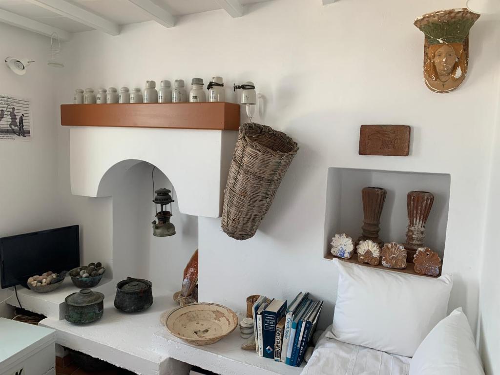 una sala de estar con una pared blanca y un estante en Anna s House in Chora en Astipalea