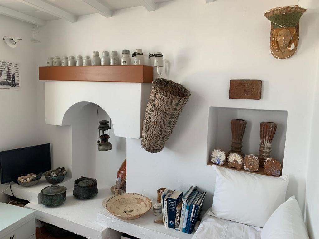 salon z białą ścianą z półką w obiekcie Anna s House in Chora w mieście Astypalea