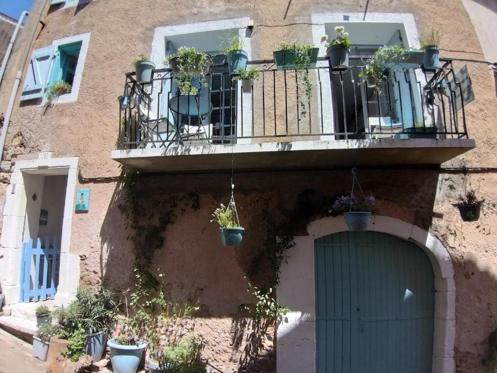 a building with a balcony with potted plants on it at La Vannière in Le Poujol-sur-Orb