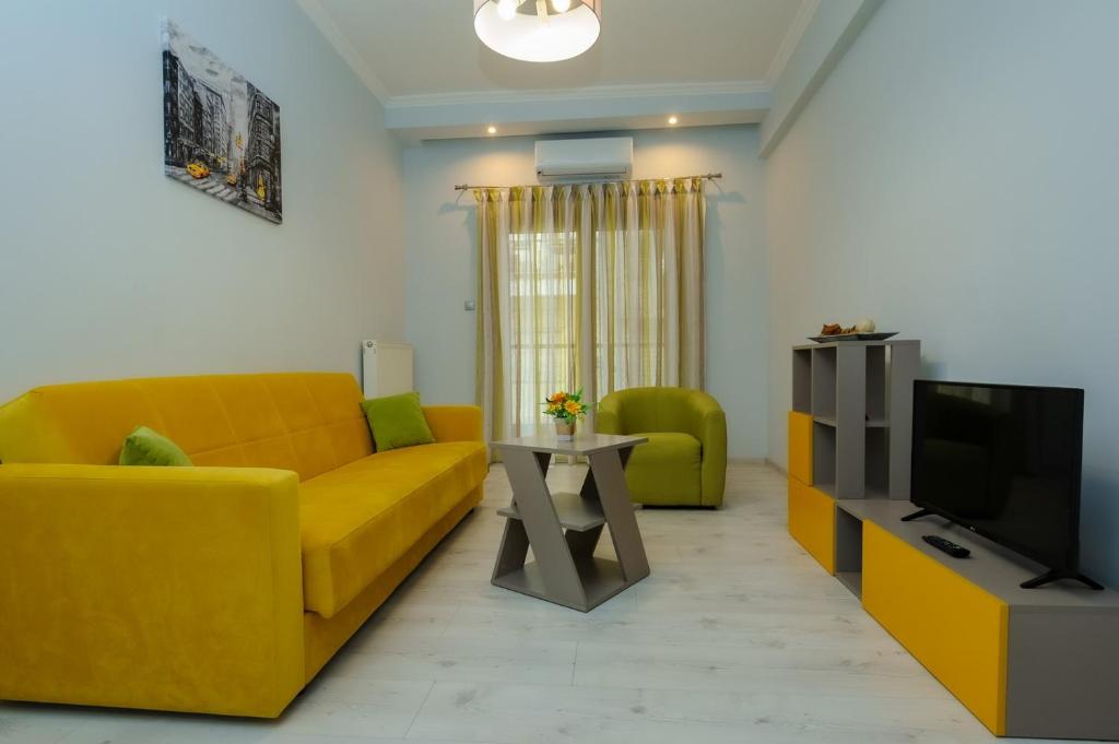 a living room with a yellow couch and a tv at 4 Colours in Thessaloniki