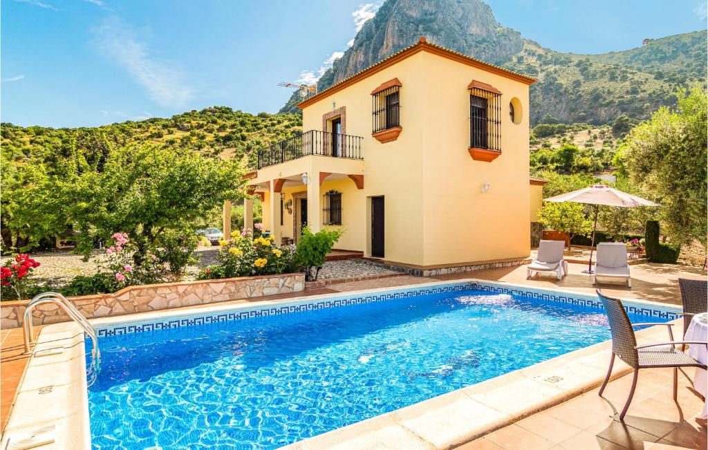 a villa with a swimming pool and a house at Cozy Home In El Gastor in El Gastor