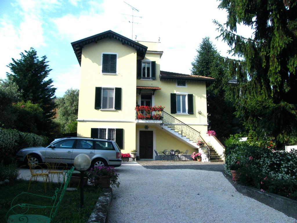 une voiture garée devant une maison jaune dans l'établissement Appartamento Villa Margherita, à Desenzano del Garda