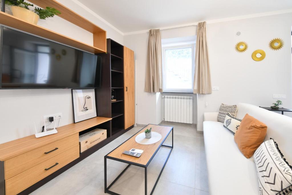 salon z białą kanapą i telewizorem w obiekcie CASA ARIANNA w mieście Ischia
