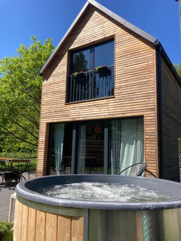 een huis met een groot raam en een rond zwembad bij Domek z Jacuzzi in Mrzeżyno