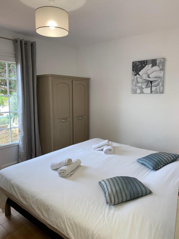 a bedroom with a white bed with two towels on it at Résidence Les Mandiles in Cargèse