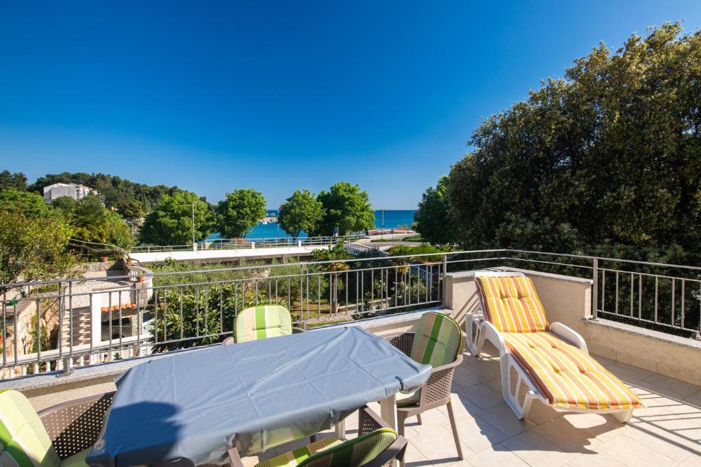 a patio with a table and chairs on a balcony at Apartment PORTAPISANA just 50m from the beach in Krk