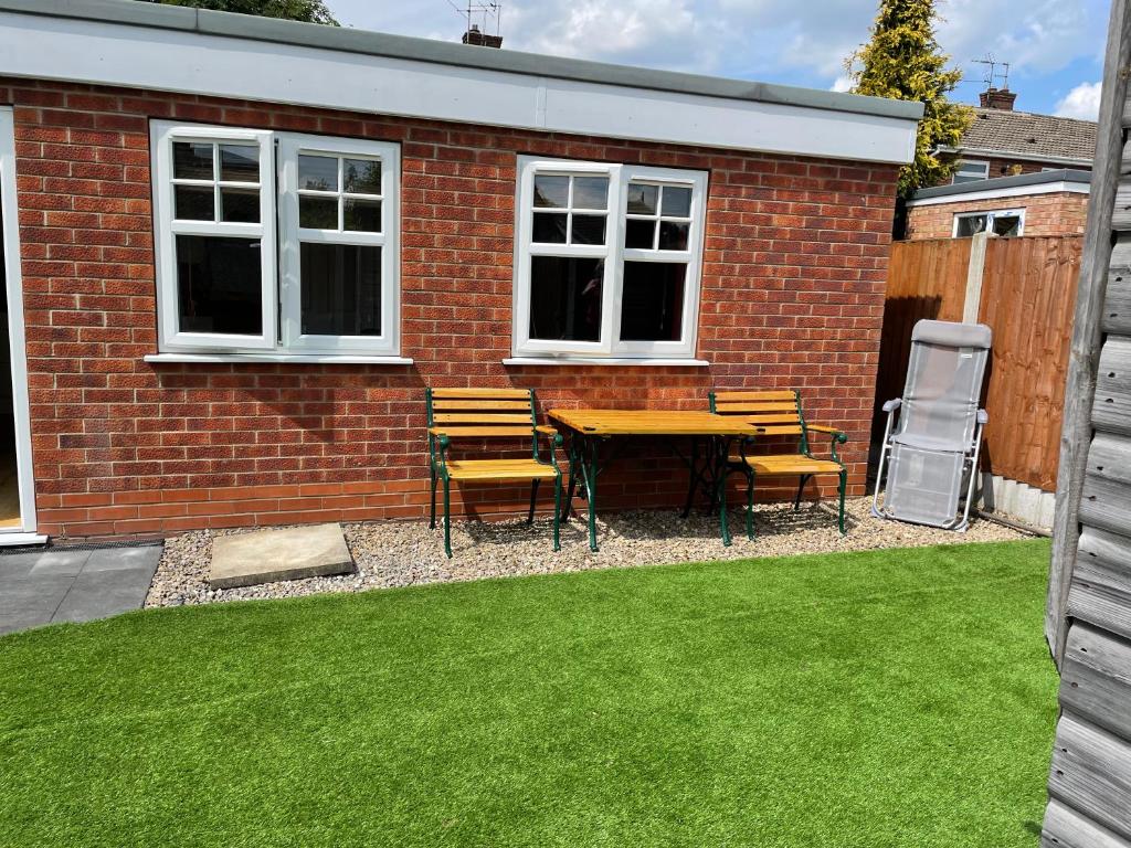 a patio with a table and chairs in a yard at Garden flat near the University of York in York