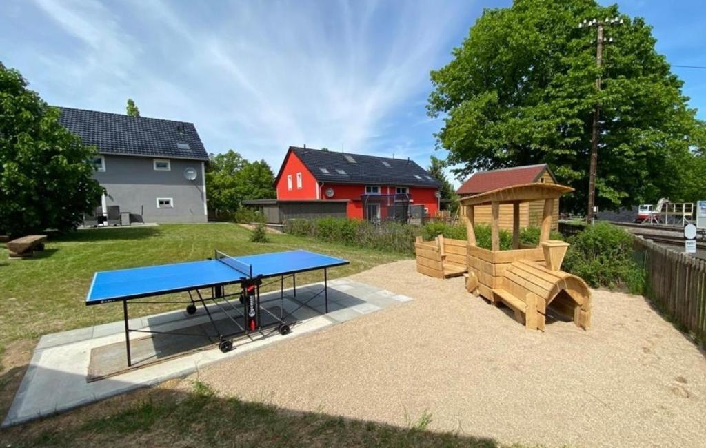 un parque infantil con mesa de ping pong y bancos en Ferienhaus Bimmelbahn 2 en Olbersdorf