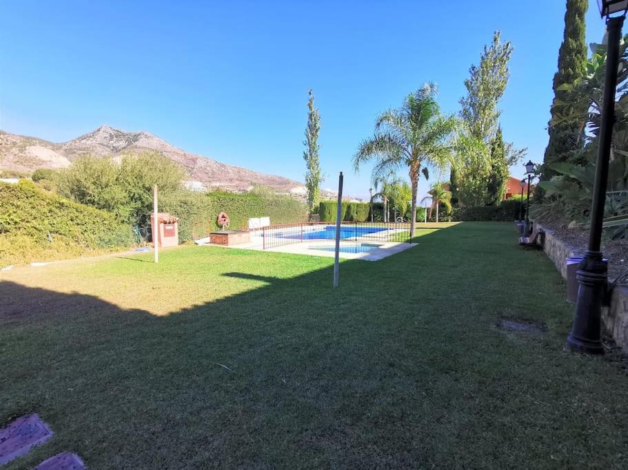 a yard with a swimming pool and palm trees at casa pareada espectacular in Benalmádena