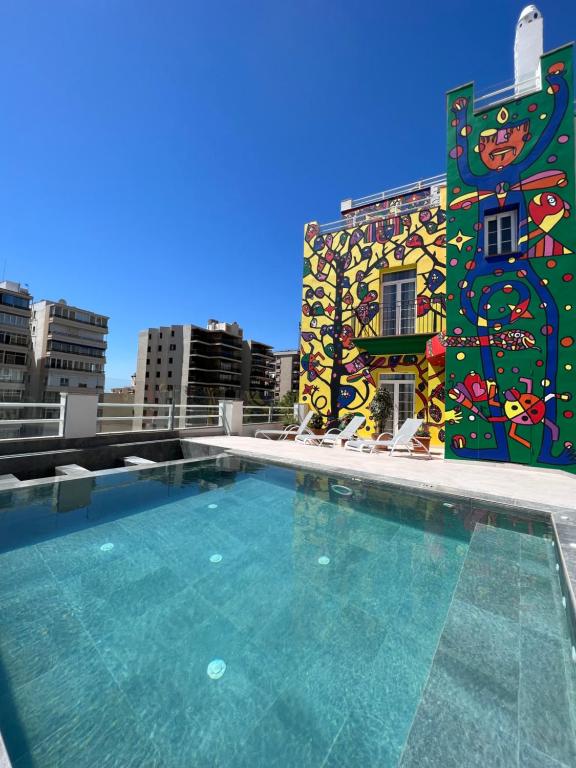 a large swimming pool with a mural on the side of a building at Hotel Artmadams in Palma de Mallorca