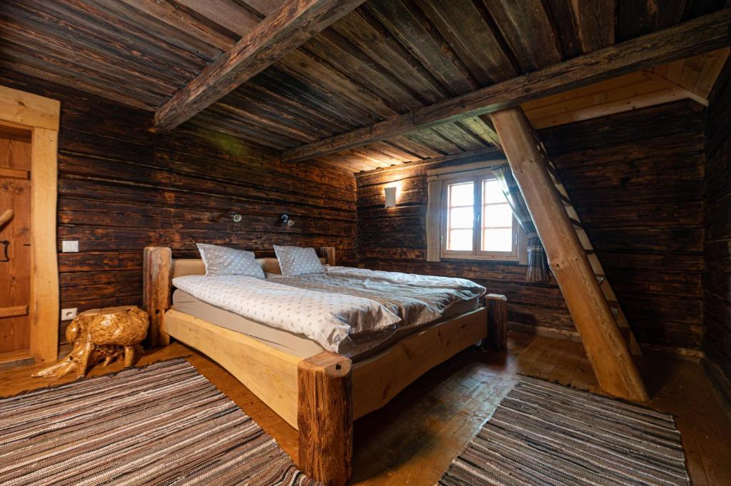 a bedroom with a bed in a log cabin at Pruuli Vahtra puhkemaja in Kraavi