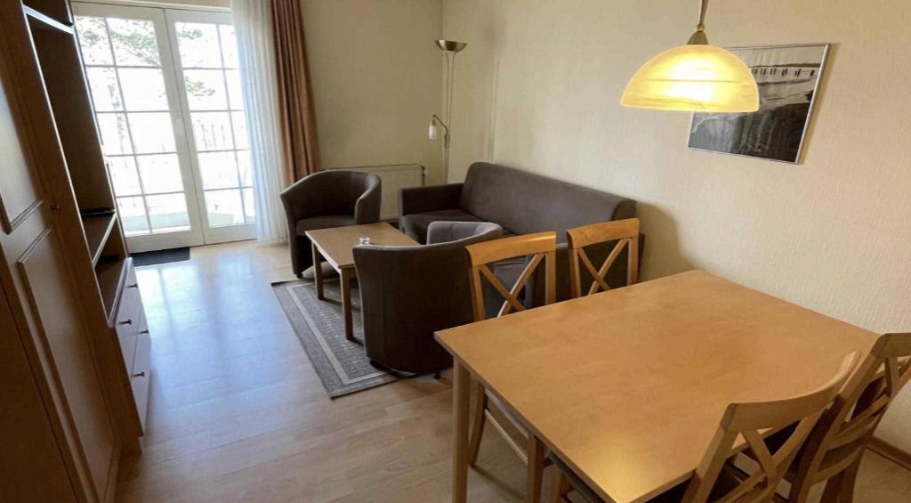 ein Wohnzimmer mit einem Sofa, einem Tisch und Stühlen in der Unterkunft Haus Kiek Ut Apartment 24 in Timmendorfer Strand