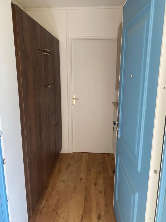 an empty room with a blue door and a closet at Studio quartier prisé de la Genette in La Rochelle
