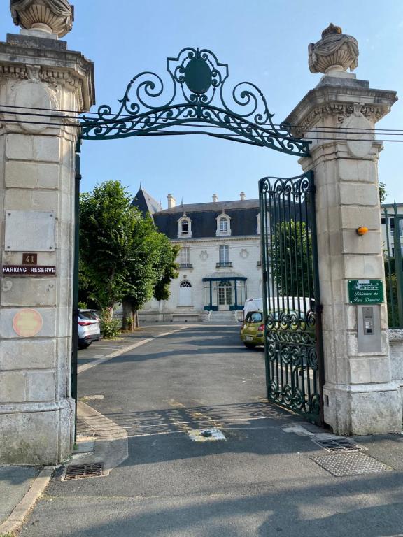 une porte en fer menant à une maison avec une allée. dans l'établissement Studio quartier prisé de la Genette, à La Rochelle