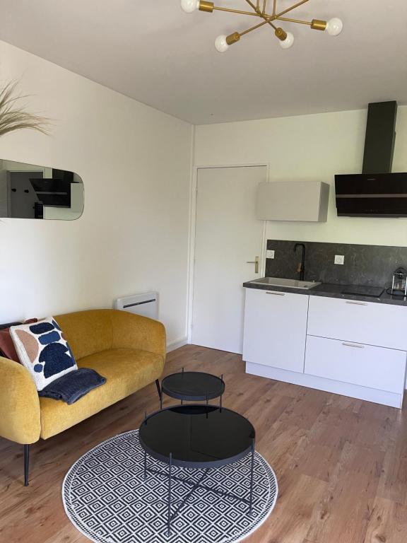 a living room with a couch and a table at Studio quartier prisé de la Genette in La Rochelle