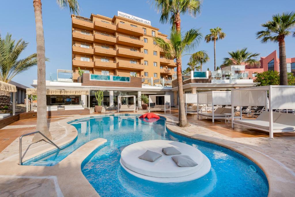 una piscina con un hotel en el fondo en Marins Beach Club - Adults Only Hotel en Cala Millor