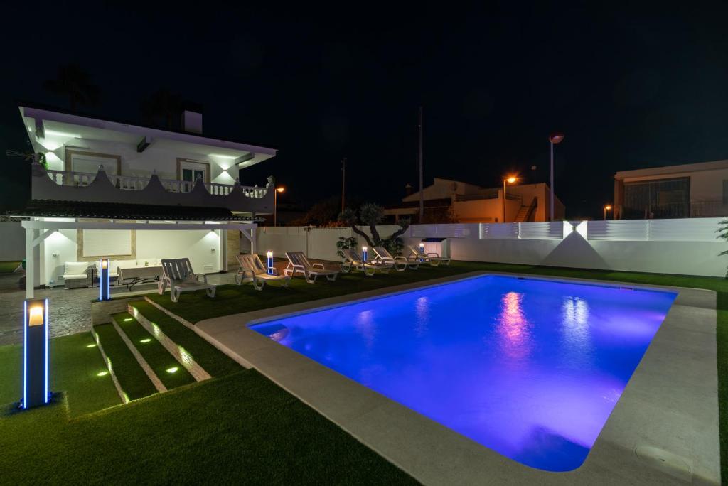 a swimming pool in the yard of a house at night at DREAM HOUSE in Burriana