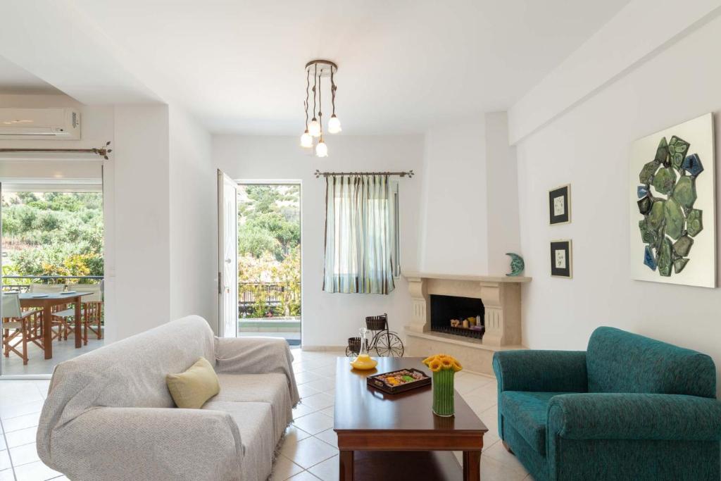 a living room with two chairs and a table at Haris Villas in Keratokampos