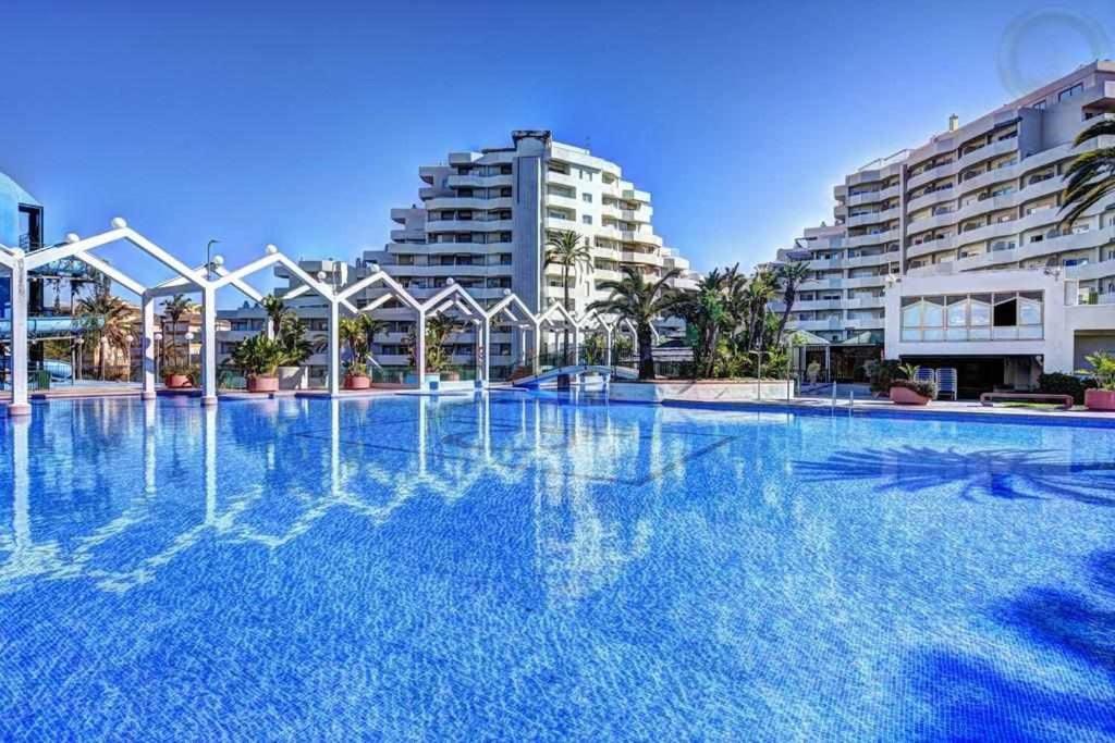 uma grande piscina em frente a alguns edifícios em VIVE BENALMADENA ESTUDIO BENAL BEACH 4-314 em Benalmádena