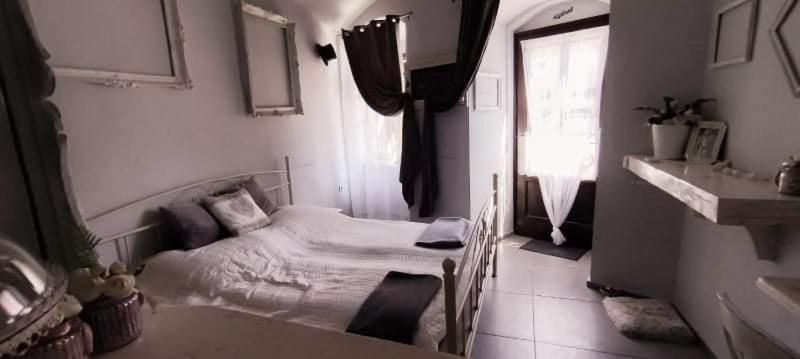 a small bedroom with a bed and a window at Godot Apartman in Miskolc