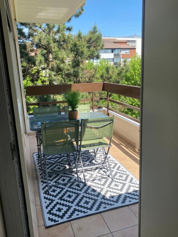 eine Terrasse mit einem Tisch und Stühlen auf dem Balkon in der Unterkunft Chez Tata Emma in Annecy