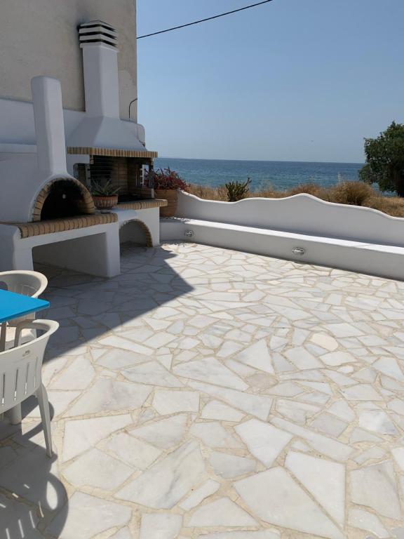 un patio con suelo de piedra y chimenea en Blue Sea Villa & Apartments en Makry Gialos