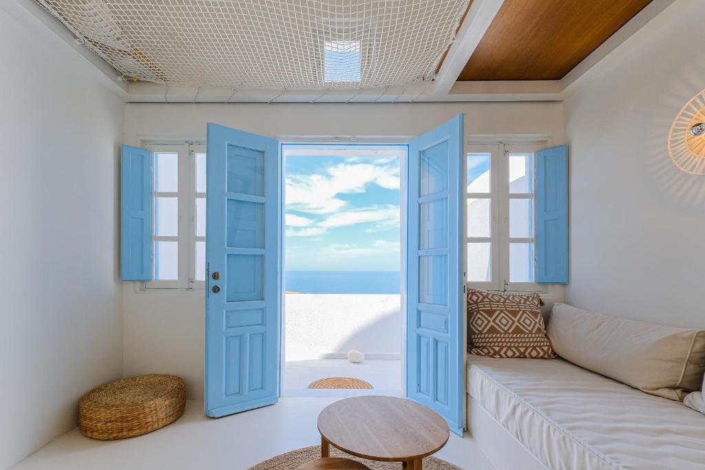 Habitación con puerta azul y sofá en SunSea Living Suites, en Vourvoúlos