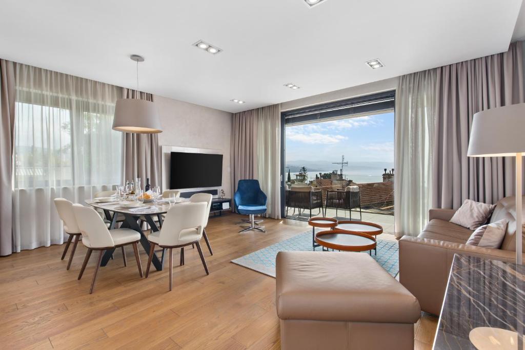 uma sala de estar com uma mesa e cadeiras e um sofá em Luxury Apartment Iris Adriatica ***** em Opatija