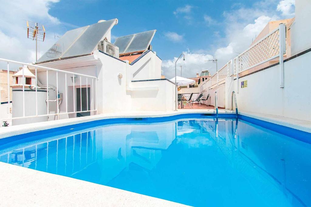 une grande piscine bleue à côté d'un bâtiment dans l'établissement Apartamentos Alan, à Nerja